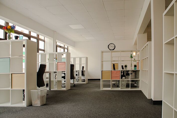 Coworking Raum mit getrennt mit Regalen.